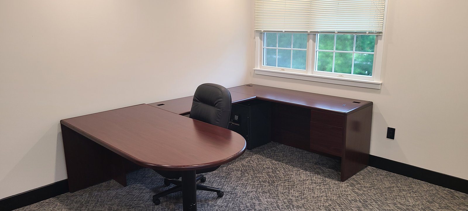 Executive office with window and L-shaped desk